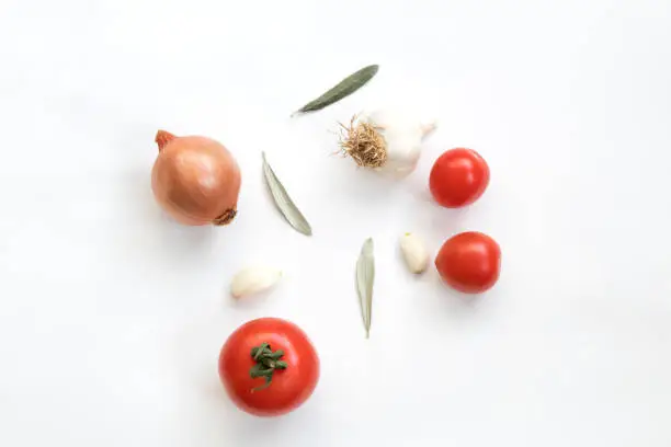 Photo of Tomatoes garlic and onion isolated on white background. Top view.