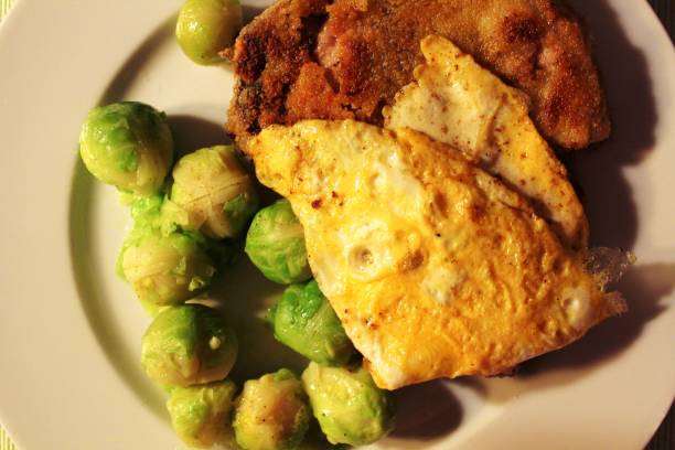 Breaded chop with Brussels sprouts and egg Chops, pork, cabbage, Brussels sprouts, egg, omelet, nutmeg, plate gemüsekohl stock pictures, royalty-free photos & images
