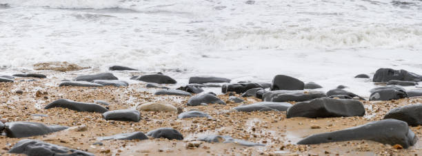istock Stones at a sandy pebble beach with the sea withdrawing 1127418666