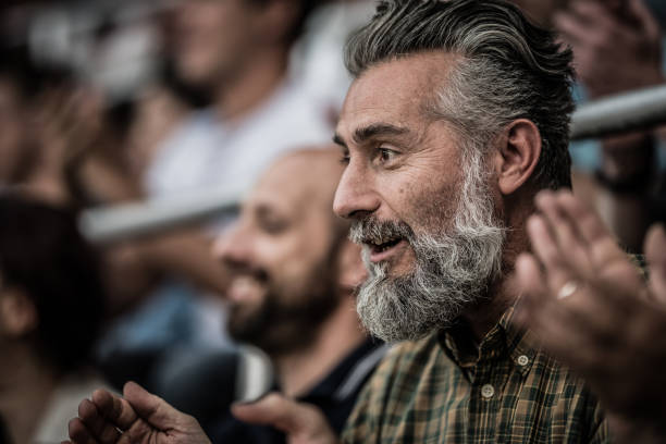 возбужденный мужчина средних лет с седыми волосами и бородой - bleachers sport soccer fan стоковые фото и изображения