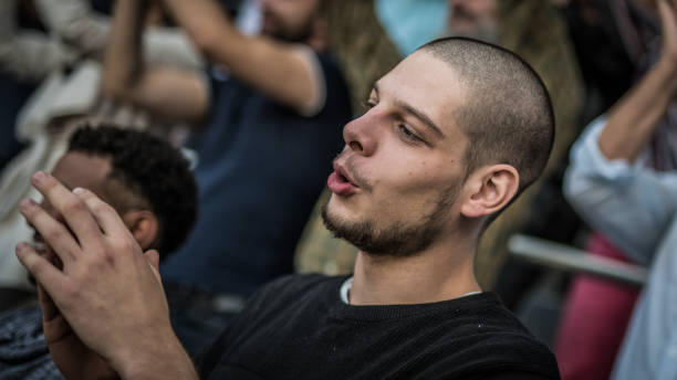 istock Young man clapping and cheering at a sports match 1127427781