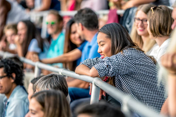 istock Young Asian woman sitting on a stadium 1127427782