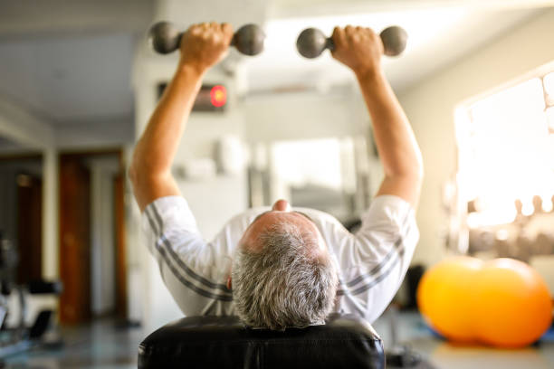 Man using dumbbells Seniors at gym senior bodybuilders stock pictures, royalty-free photos & images