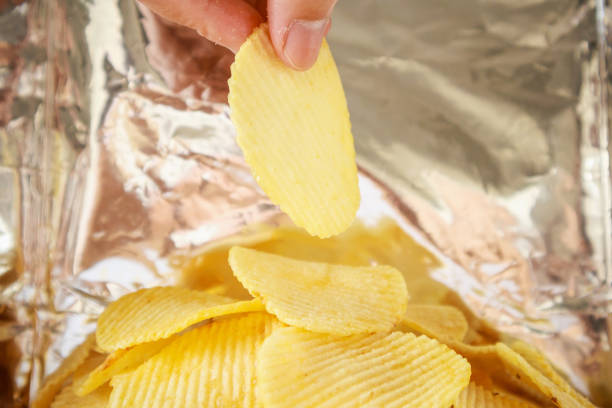 istock Hand hold potato chips inside snack foil bag 1127431732