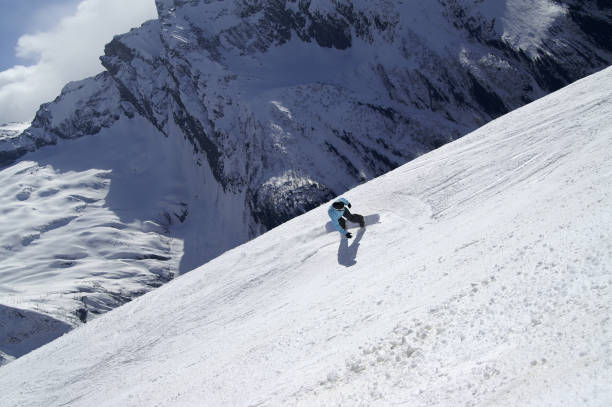 istock Snowboarder descends on off-piste ski slope 1127432561