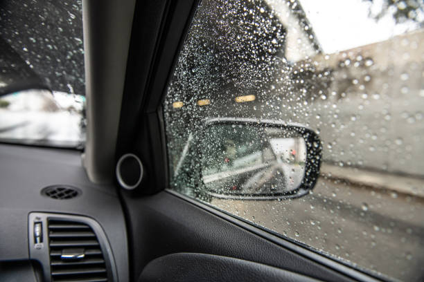 Photo through the passenger window of the side mirror on a wet gloomy day.