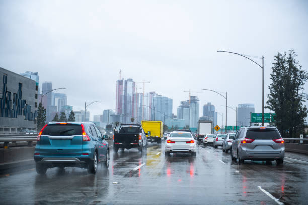 LA Freeway And Cityscape On A Rainy Gloomy Day Traffic on a Los Angeles freeway with the cityscape in the background on a gloomy overcast day. car point of view stock pictures, royalty-free photos & images