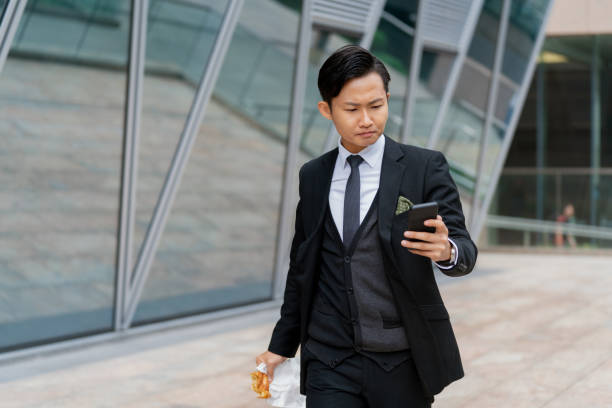 istock Young businessman using his phone outdoors 1127450265