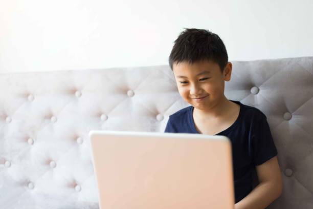 istock Little boy using laptop play game at home for relax 1127453532