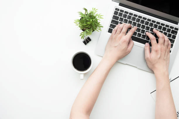 istock Young man is typing on laptop keyboard over white office desk. Top view with copy space, flat lay. 1127454120