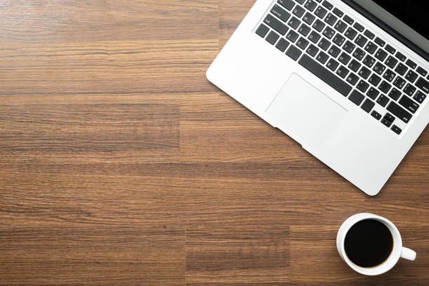 istock Wood office desk table with laptop computer and a cup of coffee. Top view with copy space, flat lay. 1127454132