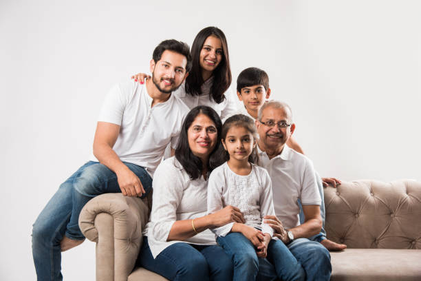 famiglia indiana / asiatica seduta sul divano o sul divano su sfondo bianco - grandfather adult affectionate little boys foto e immagini stock