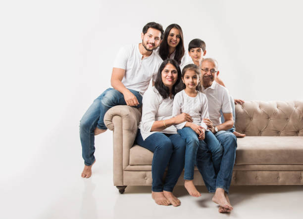 famiglia indiana / asiatica seduta sul divano o sul divano su sfondo bianco - grandfather adult affectionate little boys foto e immagini stock