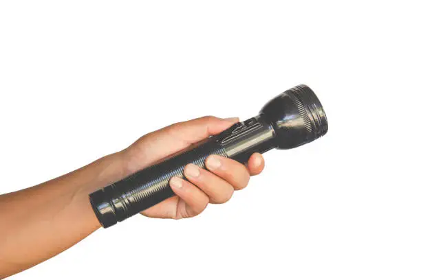 Hand holding black flashlight isolated on white background - concepts of searching and direction. Clipping path inside.