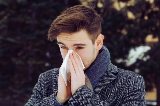 istock Sick young man blowing his nose 1127462716