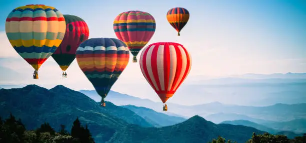 Panoramic of mountain with hot air balloons on morning at Thailand.