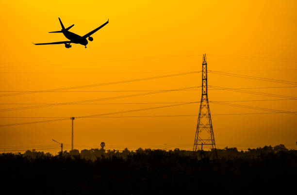 istock Airplane flying over the electtric pole at sunset. 1127463789
