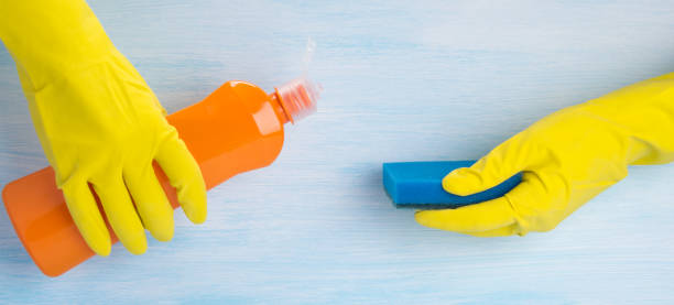 istock close-up, hands in protective rubber gloves, pour cleaning agent on a sponge, on a blue background 1127464427