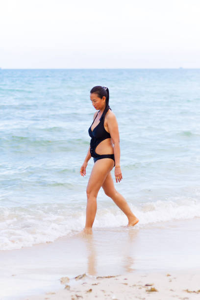 istock Woman shape big with black bikini walk on beach 1127468382