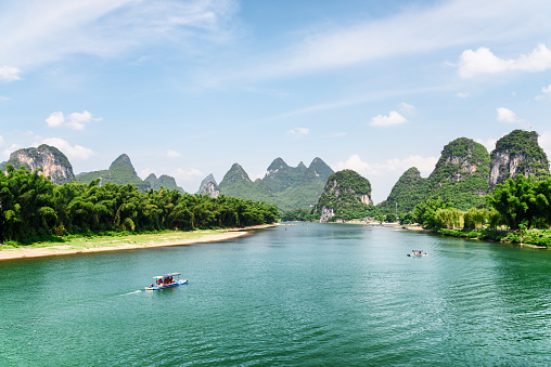 Amazing view of the Li River (Lijiang River) with azure water at Yangshuo County of Guilin, China. Beautiful karst mountains are visible on blue sky background on summer sunny day. Wonderful landscape