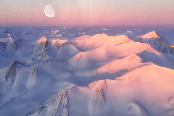 le cime delle montagne dell'isola di ellesmere si bagnavano di luce mentre il sole cominciava a raggiungere il picco all'orizzonte. elementi di questa immagine forniti dalla nasa - sunrise mountain winter arctic foto e immagini stock