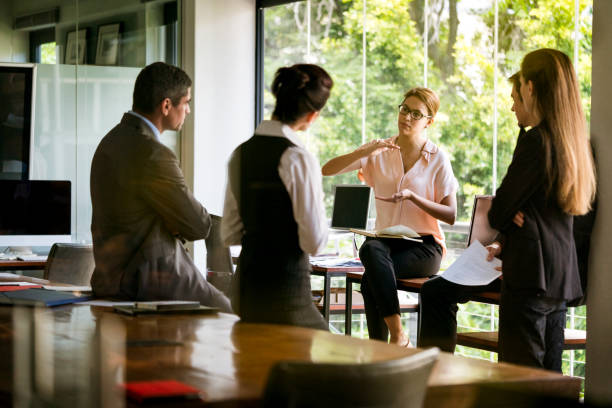 istock Entrepreneur gesturing to coworkers in board room 1127470636