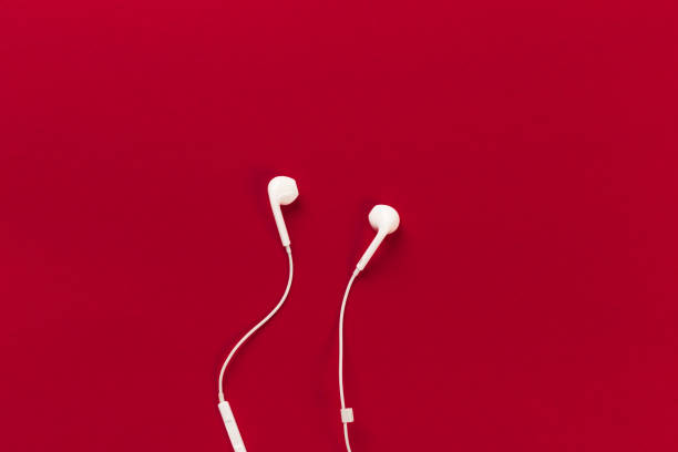 istock White earphones on red background 1127471279