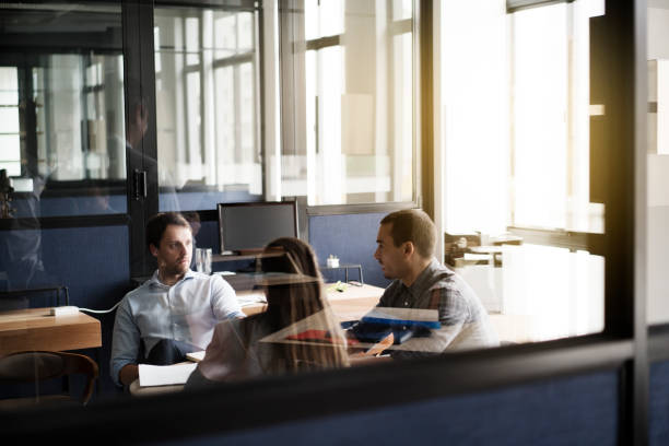 istock Business people discussing while sitting at desk 1127471285