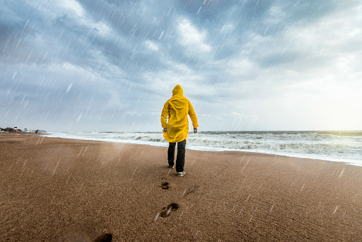 Man on the beach on a rainy day