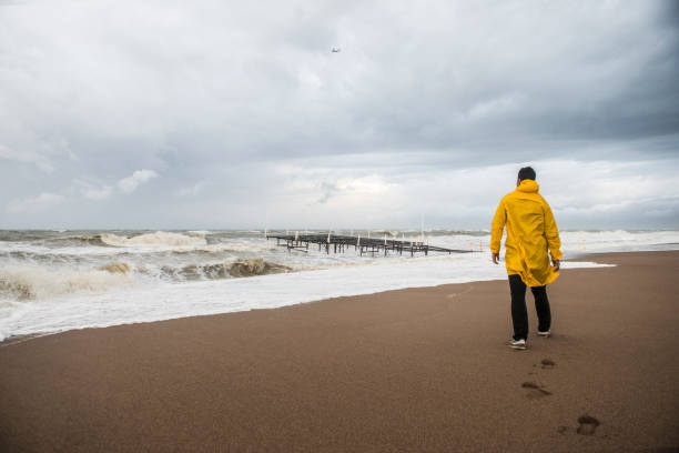 Man on the beach on a rainy day