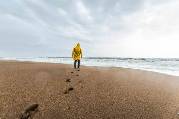 istock Man on the beach on a rainy day 1127472788