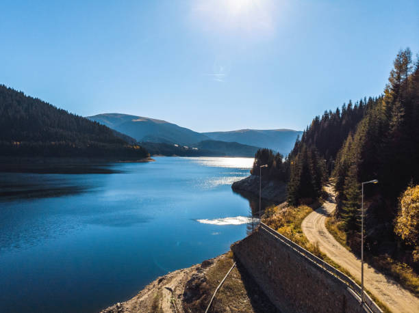 istock road at lake and forest 1127474789