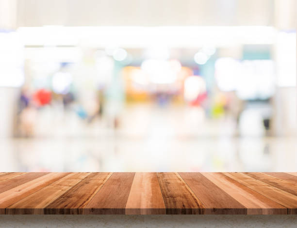istock Empty wood table top with blur department store boekh background,Mock up template for display or montage of product or content use as banner in social media ads. 1127475163