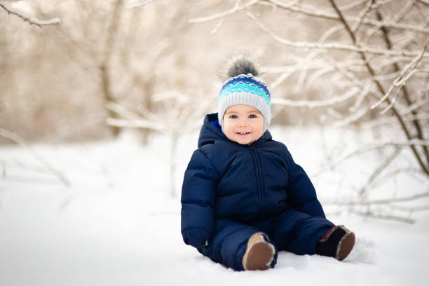 baby boy sitting on snow stock photo