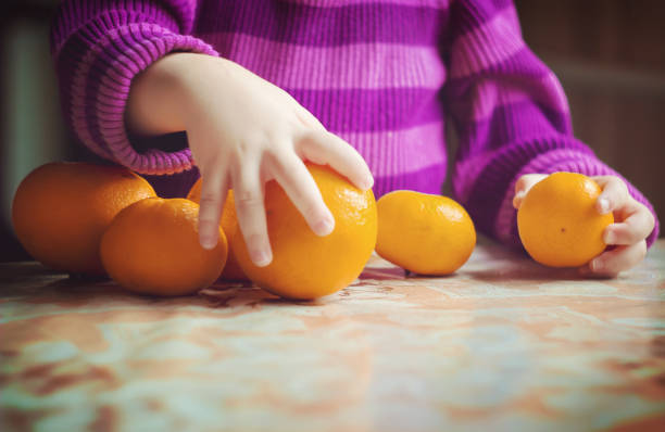 Child and tangerine. Selective focus. food and drink.