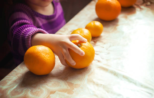 Child and tangerine. Selective focus. food and drink.