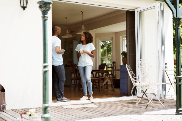 istock Couple with coffee cups talking at doorway 1127478662