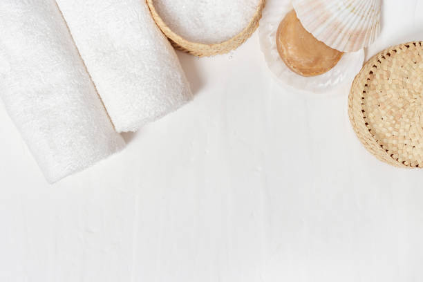 istock Spa accessories - white towels, round soap, sea salt on concrete background with copy space. Items for bathroom.Top view. 1127478925