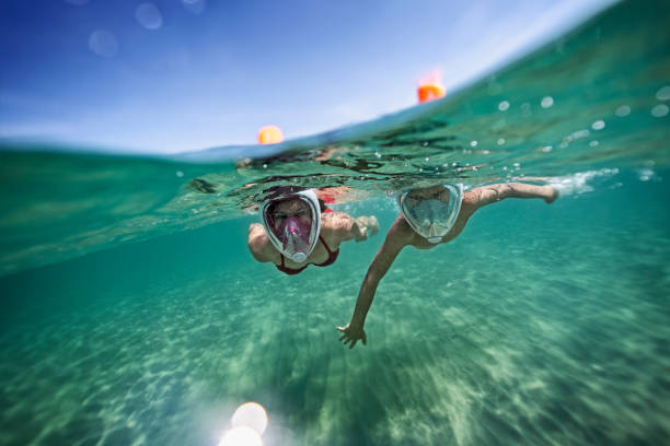 兄と妹の海の水中水泳 - スキューバマスク ストックフォトと画像