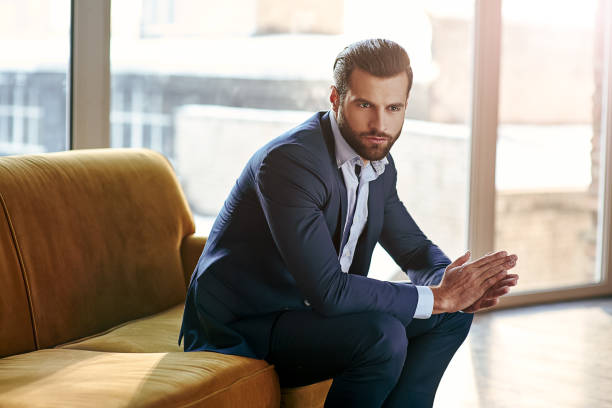 confident and concentrated. thoughtful handsome businessman is thinking while sitting in his modern office about business concept while sitting on sofa - símbolo sexual imagens e fotografias de stock