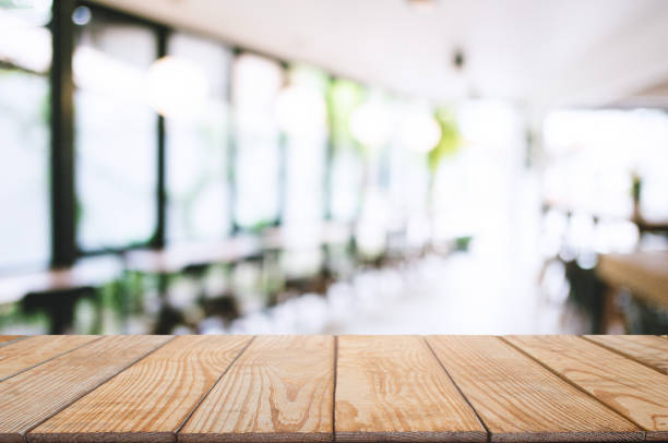 istock wooden table with blurred montage coffee shop cafe background. 1127484432