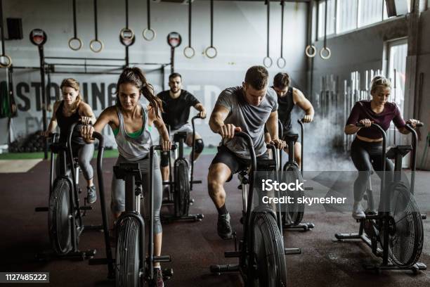 Gym Training On Stationary Bikes Stock Photo - Download Image Now - Gym, Exercising, Health Club