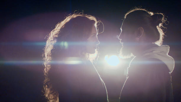 istock Couple standing in front of a car at night 1127487143