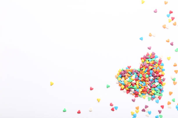 Colorful heart shaped sprinkles on white background