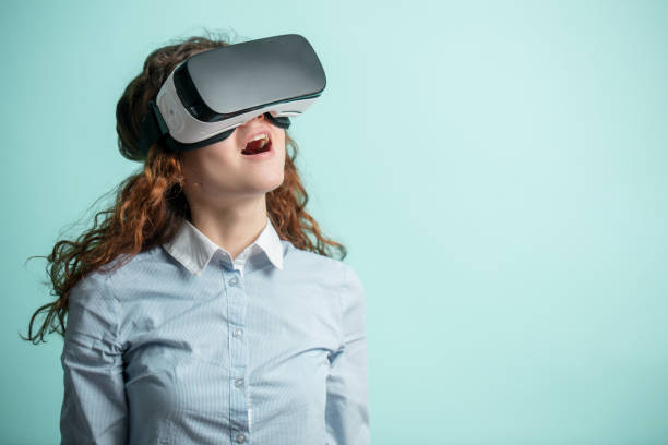 ginger girl in virtual reality goggles. isolated blue background. copyspace