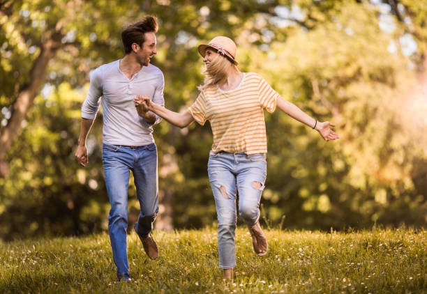 istock Cheerful couple having fun while holding hands and running in nature. 1127488270