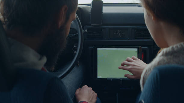 istock Cheerful young couple on road trip. Picking direction with tablet. 1127489298