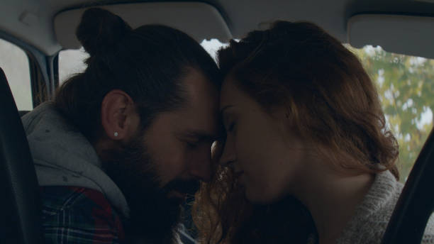 istock Young couple sitting in a retro car, cuddling 1127489329