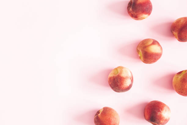 istock Peaches on pastel pink background. Frame made of fresh peaches. Flat lay, top view, copy space 1127489678