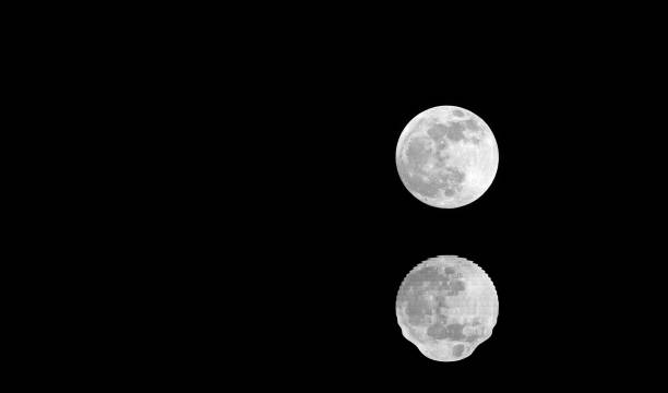istock silvery full moon with reflection on black water at midnight and 1127490300